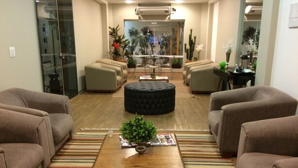 Un salon moderne avec une table basse en bois, un tapis à rayures et plusieurs canapés.