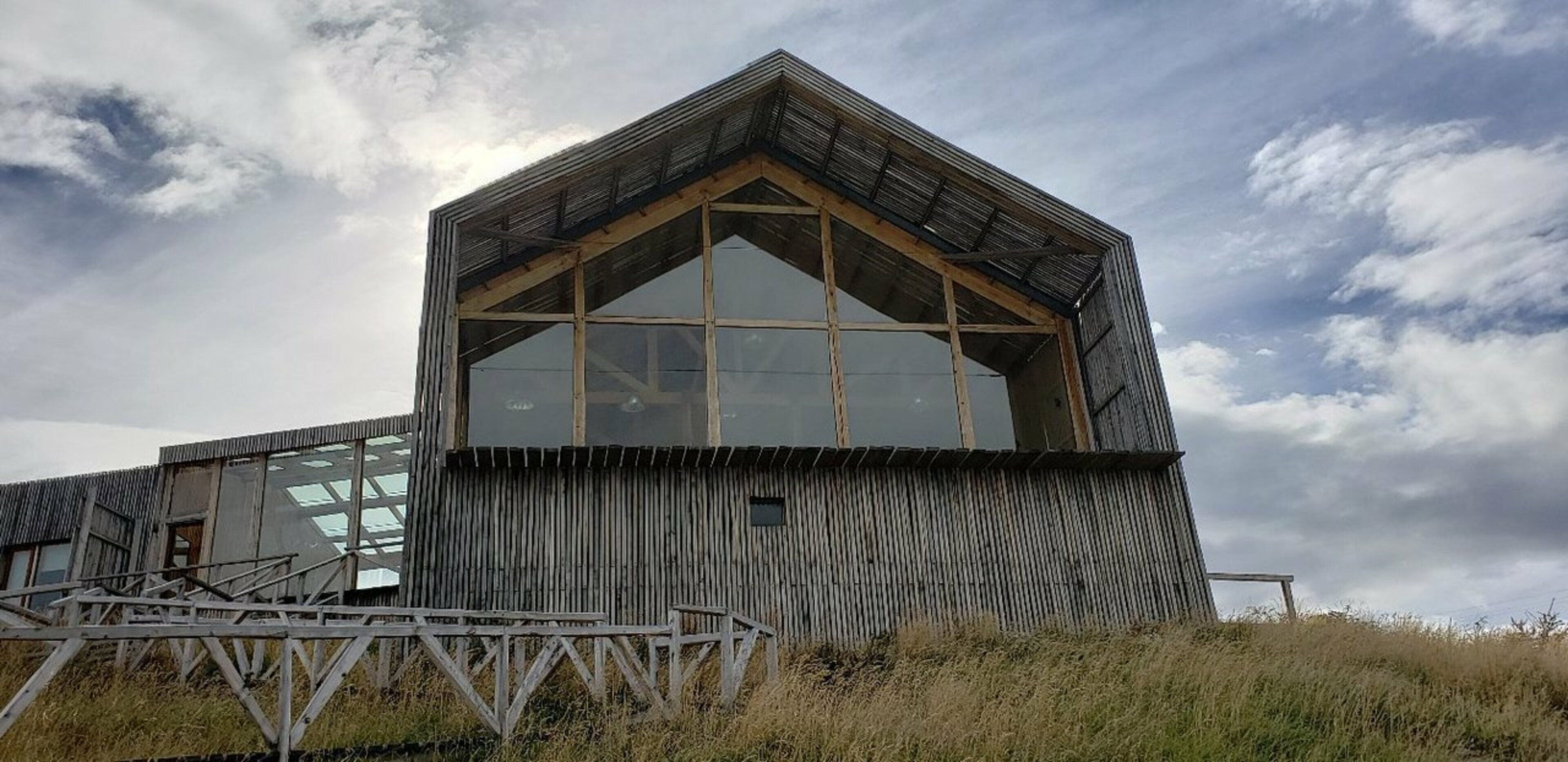 Um edifício moderno com uma ampla janela de vidro e fachada de madeira.