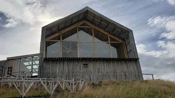Um edifício moderno com uma ampla janela de vidro e fachada de madeira.