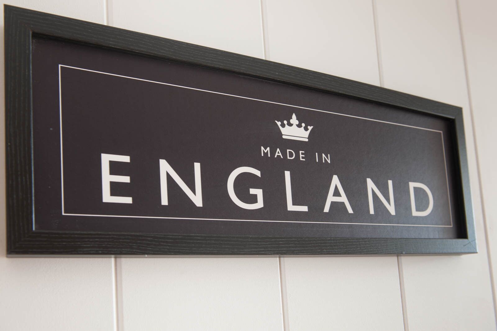 A sign with "ENGLAND" and "MADE IN ENGLAND" text, framed in dark wood.