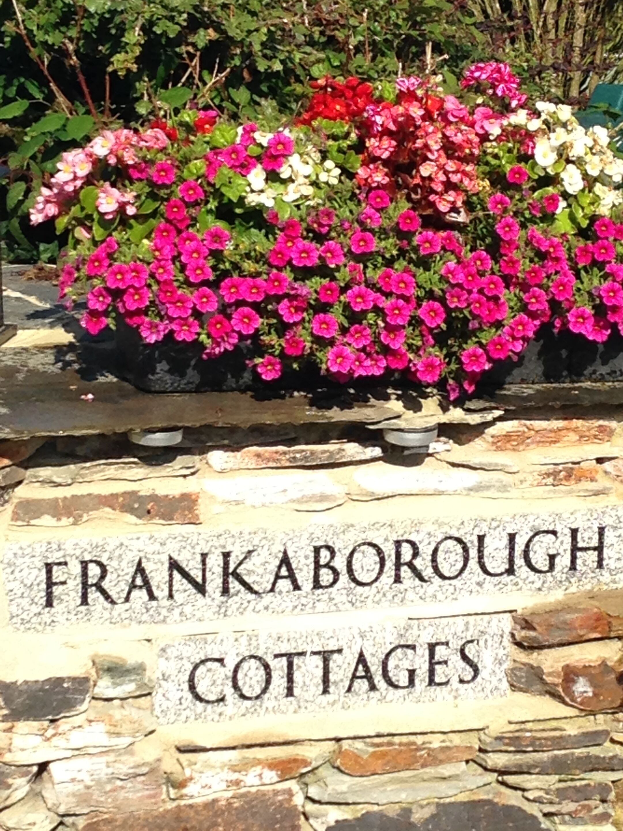 A stone wall with a sign that reads "FRANKABOROUGH COTTAGES".