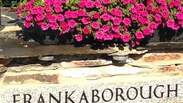 A stone wall with a sign that reads "FRANKABOROUGH COTTAGES".