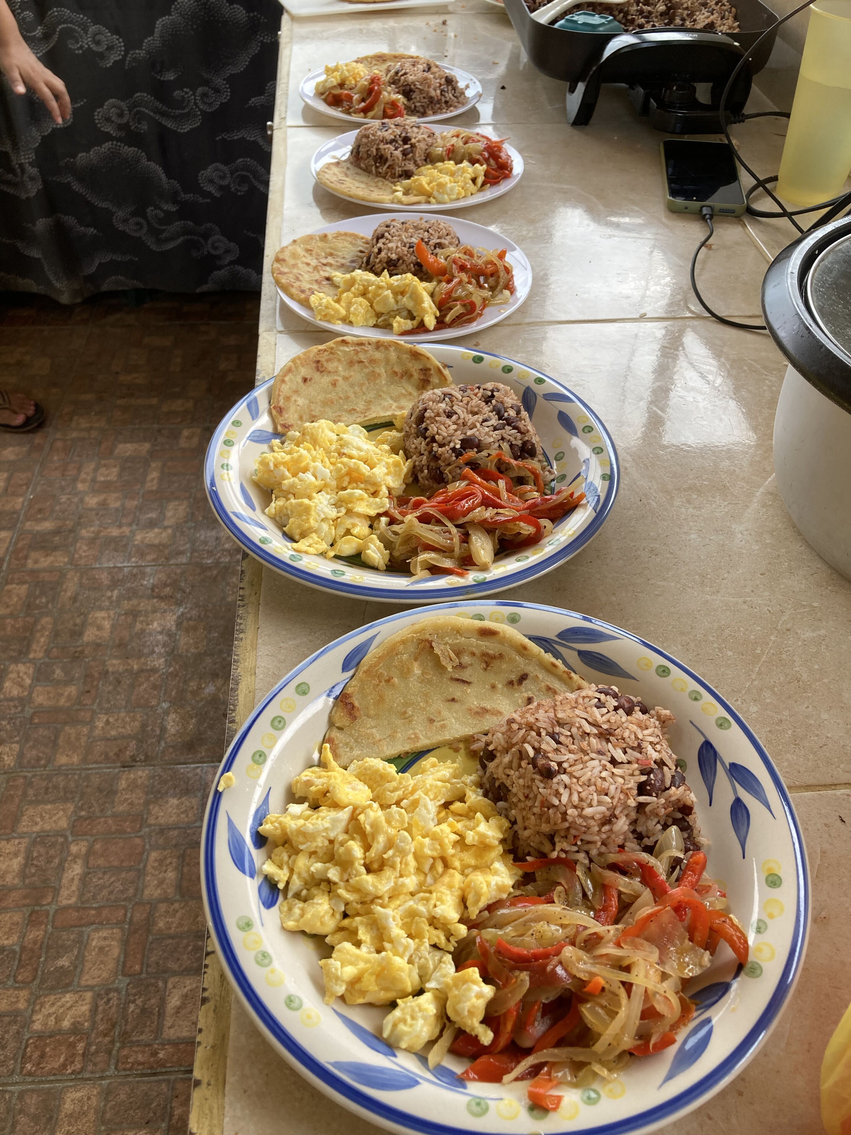 A table with plates of food, including rice, eggs, and vegetables.