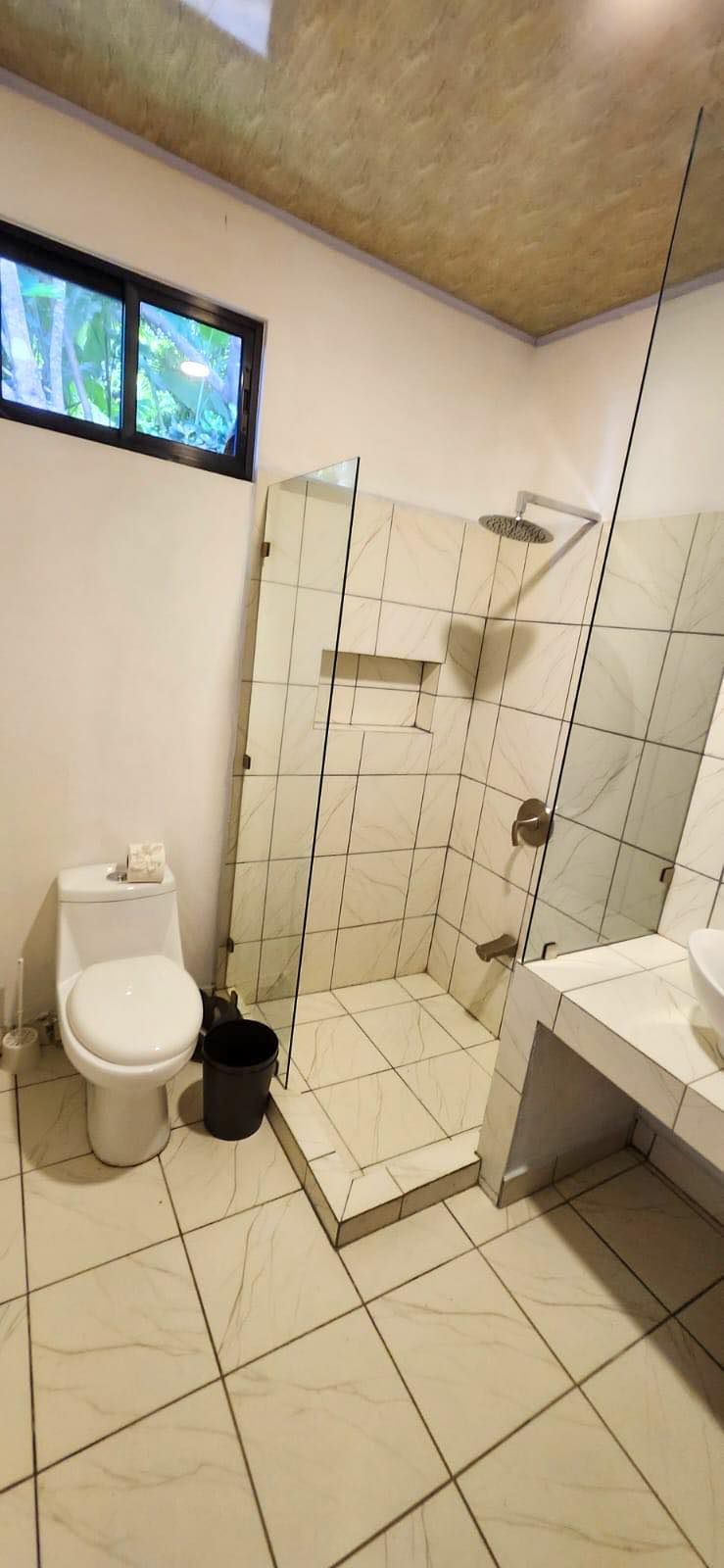 Une salle de bain moderne équipée de toilettes, d’une douche et d’un lavabo.