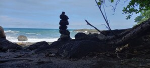 Un amas de rochers sur une plage, avec l’océan en arrière-plan.