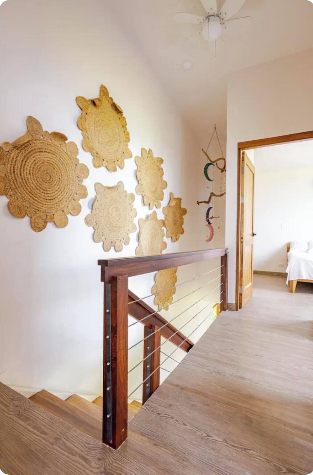 Una scala con ringhiera in legno e un muro decorato con elementi artistici intrecciati a forma circolare.