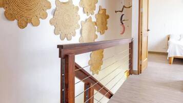 Una scala con ringhiera in legno e un muro decorato con elementi artistici intrecciati a forma circolare.