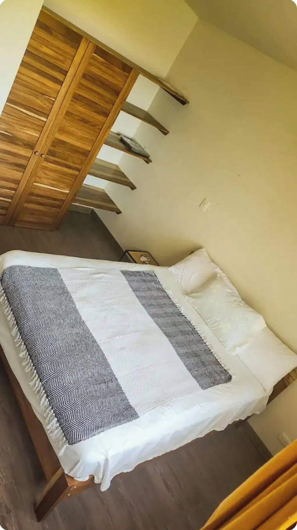 Ein Schlafzimmer mit einem Bett, einem Holzschrank und einem Nachttisch.