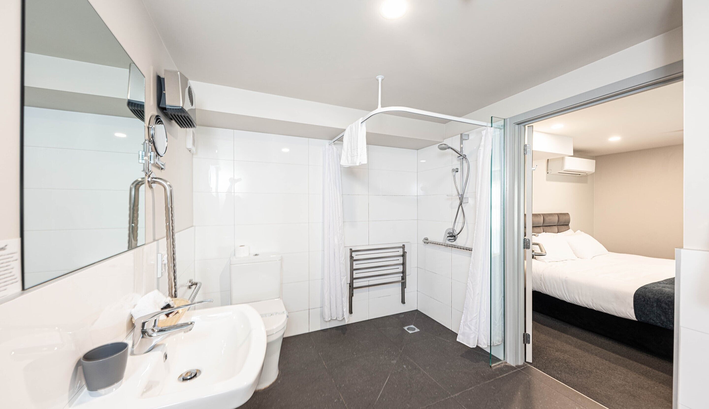 A modern bathroom with a shower, toilet, and sink.