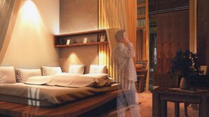 Een moderne slaapkamer met een groot bed, een nachtkastje en een houten hoofdbord.