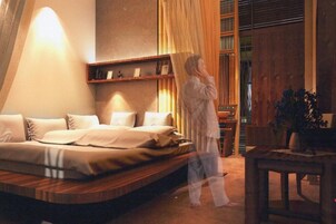 Un dormitorio moderno con una cama grande, una mesita de noche y un cabecero de madera.