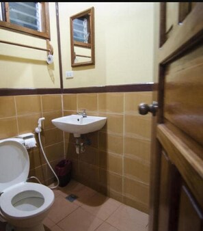 A small bathroom with a toilet, sink, and mirror. - Pems Pension and Restaurant (Taytay)