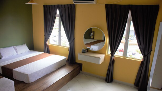 A hotel room with a bed, a bedside table, a mirror, and a window with curtains. - Aeon Tebrau Apartment Johor Bahru (Johor Bahru)