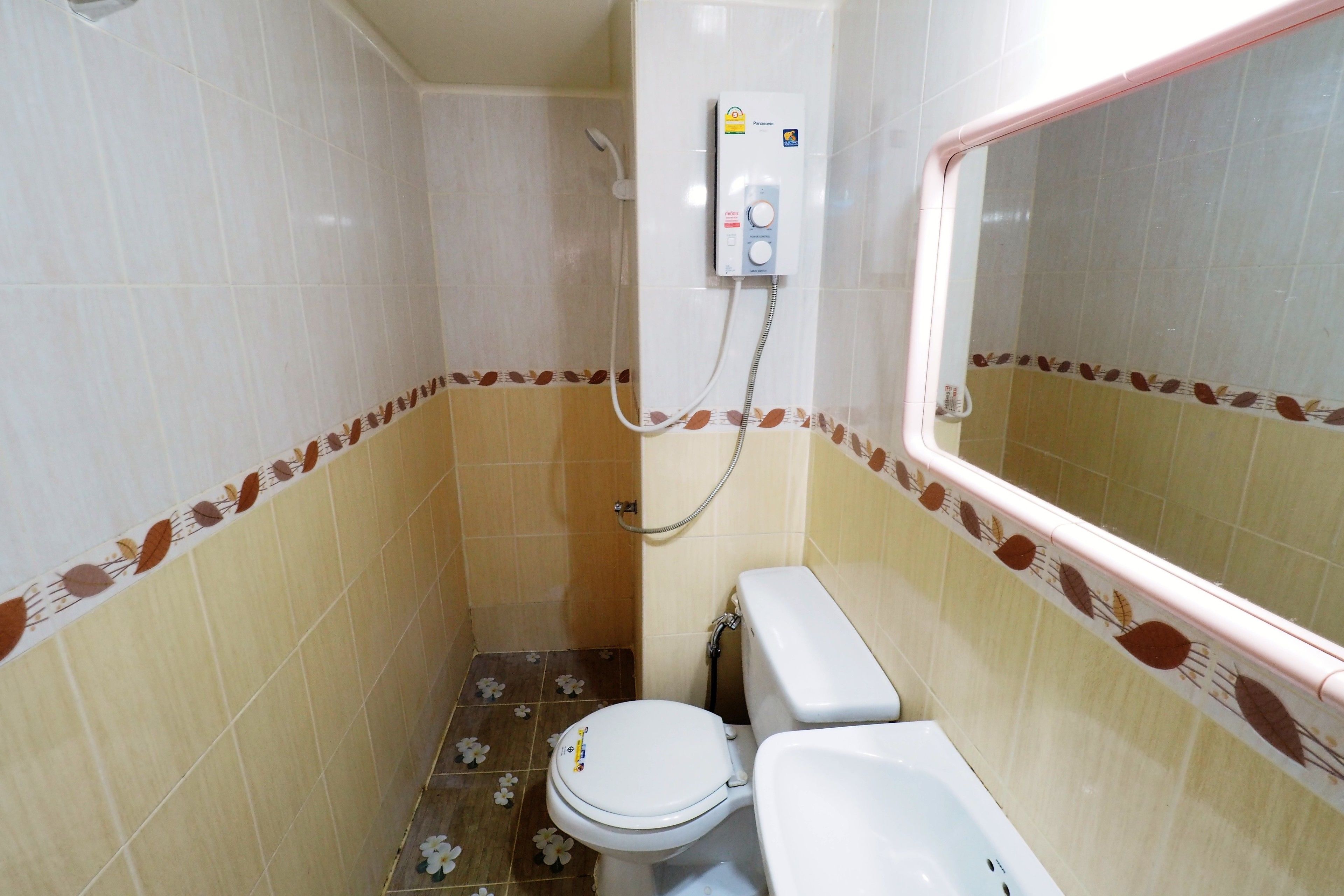 A small bathroom with a toilet, a shower, and a sink.