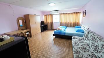 A bedroom with a bed, a sofa, a desk, and a wardrobe.