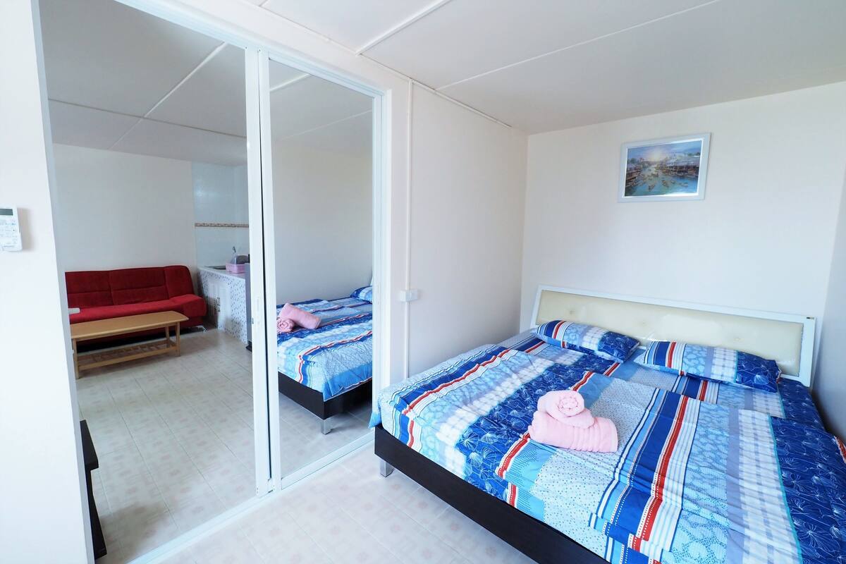 Ein Schlafzimmer mit einem Bett, einem roten Sofa und einem Spiegel.