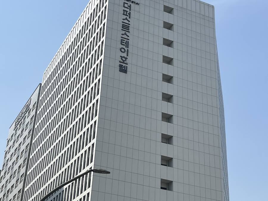 A tall, modern building with a grid-like facade and multiple windows.