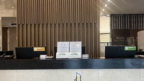 A reception desk with a modern design, featuring a logo for 'The First Stay'.