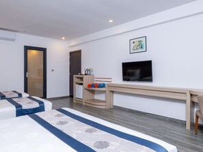 A hotel room with a bed, a desk, a television, and a door. - Kaani Grand Seaview (Maafushi)