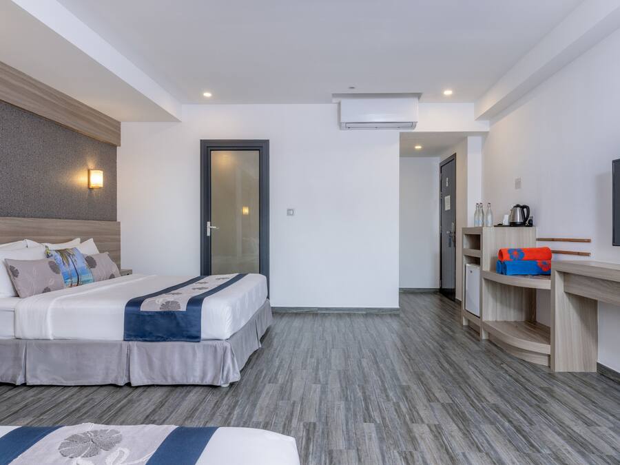 Ein Hotelzimmer mit Bett, Nachttisch und einer kleinen Küchenzeile.