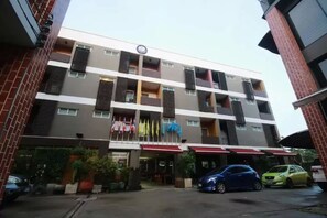 A multi-story hotel with a modern design, featuring balconies and a central entrance. - Namnon Place (Nonthaburi)