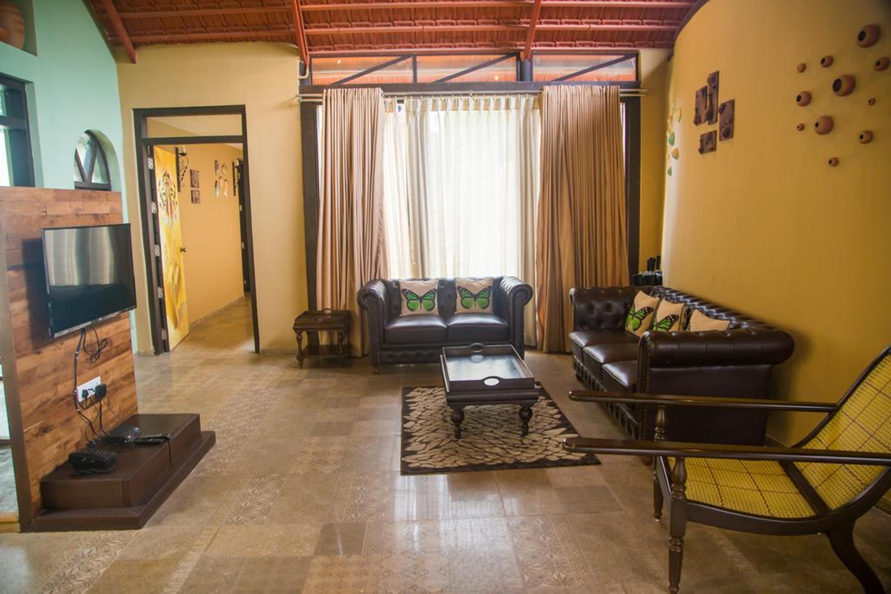 Una sala de estar con sofá, sillón, mesa de centro y mueble para televisión.