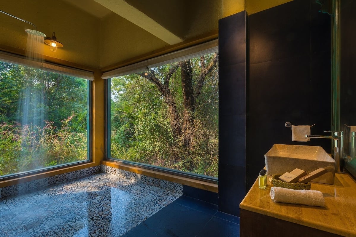 A modern bathroom with a large window, a sink with a towel, and a shower.