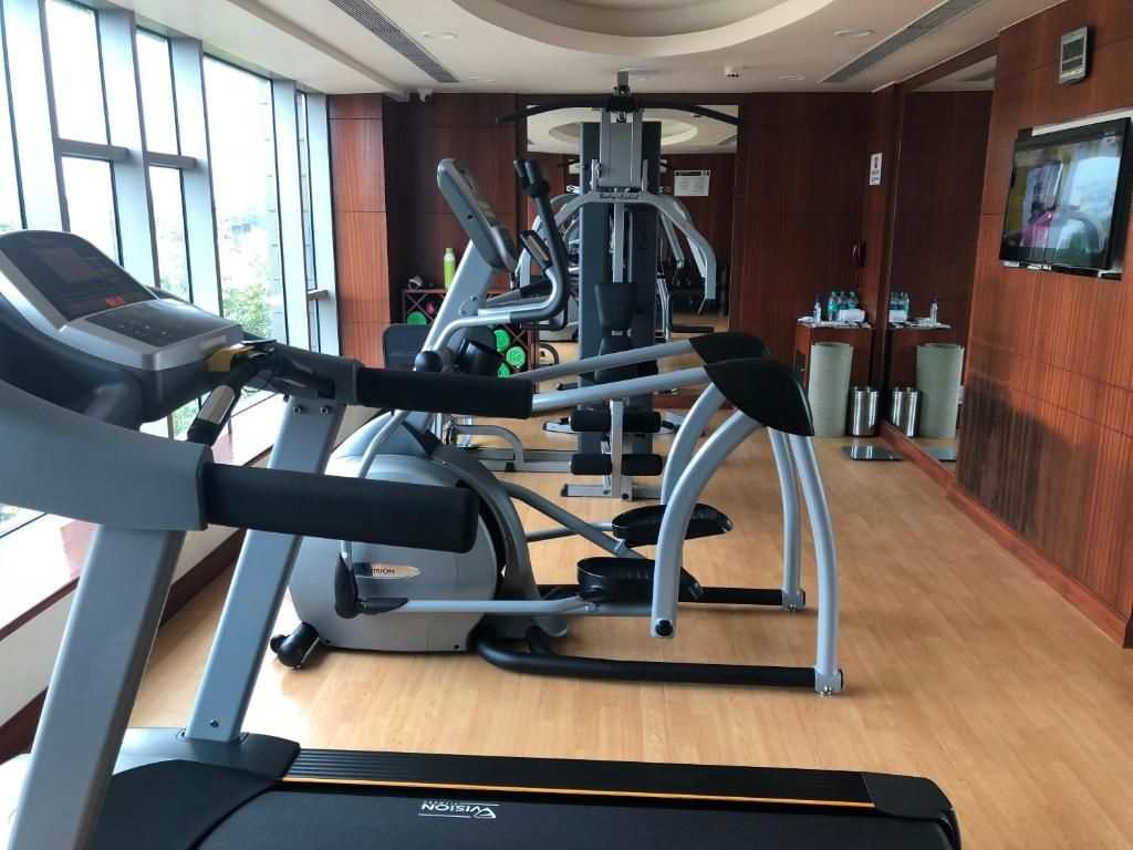 Un gimnasio con cintas de correr, elípticas y equipos de pesas.