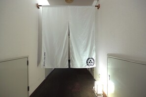 A hallway with a white curtain hanging from the ceiling, a sign on the wall reading "HIME ONLY FLOOR," and a door on the left. - Hotel Sungarden Matsuyama (Matsuyama)