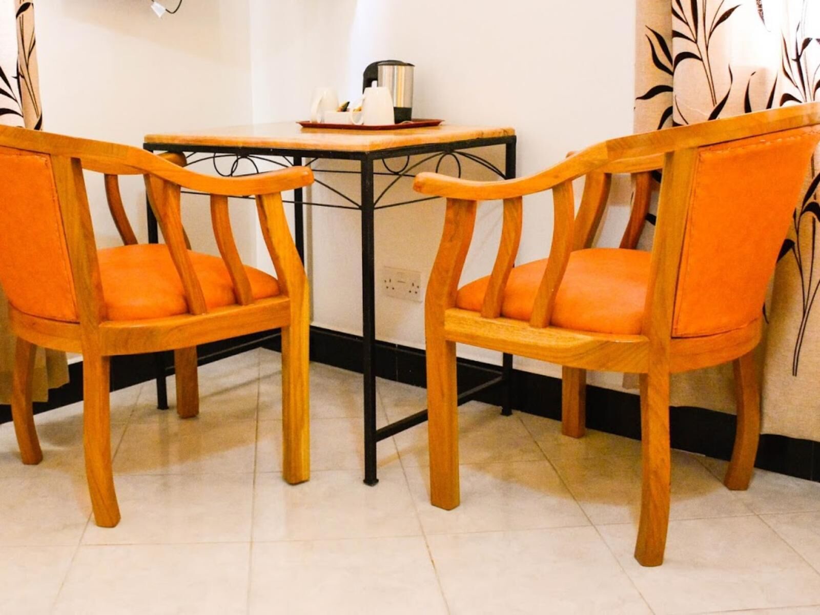 A dining area with two wooden chairs and a small table.