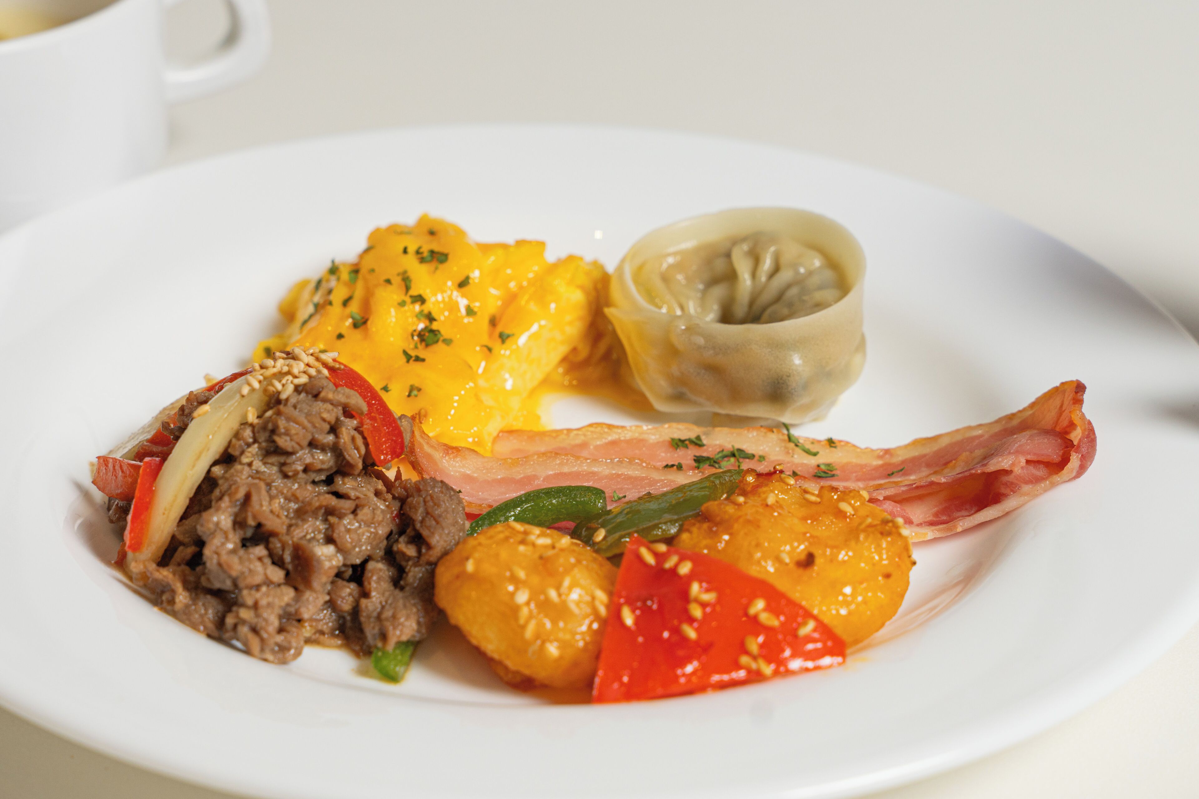 A plate with various food items including meat, vegetables, and a dumpling.