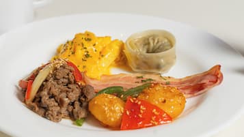 A plate with various food items including meat, vegetables, and a dumpling.