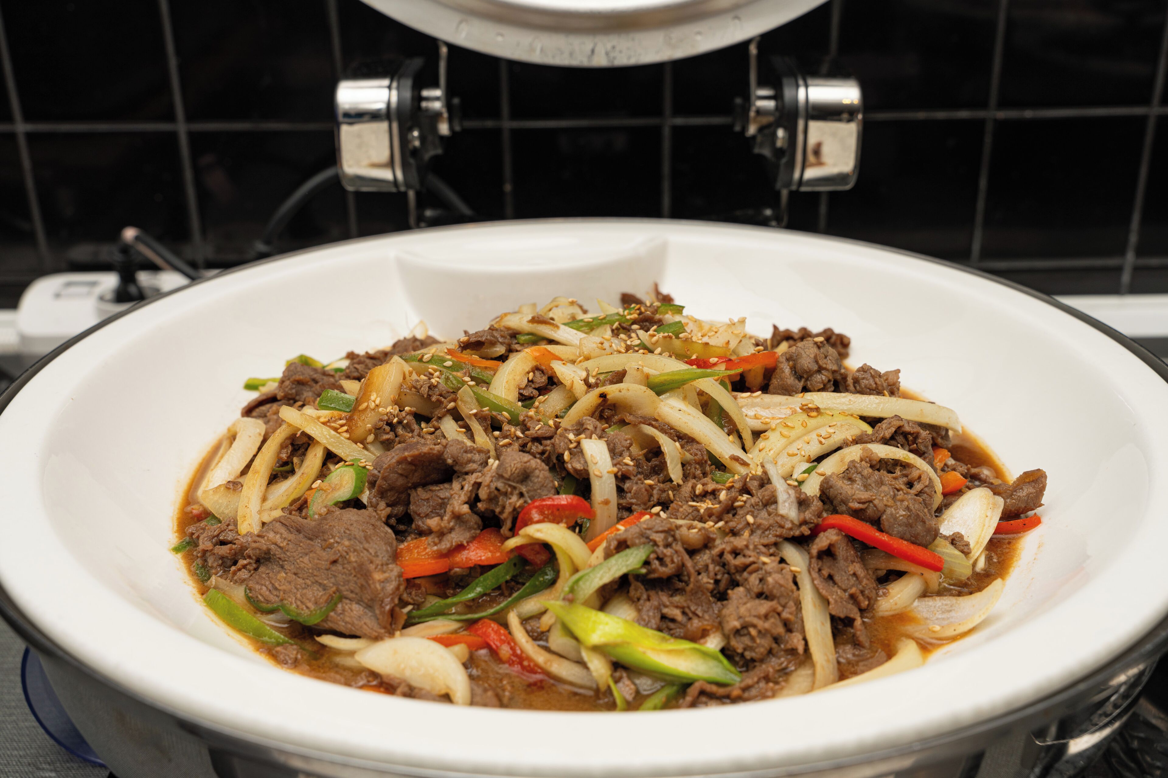 A white bowl of beef stir-fry with vegetables.