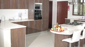 A modern kitchen with wooden cabinets, a built-in oven, a microwave, and a gas stove.