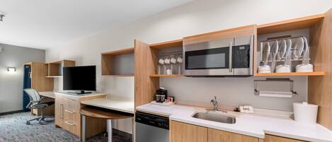A modern kitchen with wooden cabinets, a dishwasher, a microwave, and a sink.
