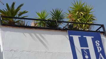 A sign with the letters "H" and "SPA" on a white wall, indicating a hotel or spa.