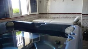 Un baño con bañera, ducha y ventana.