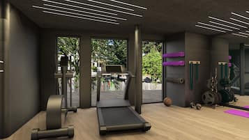Ein Fitnessraum mit Trainingsgeräten, Laufband und Blick ins Freie.