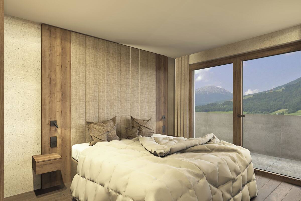 A bedroom with a large bed, a nightstand, a view of mountains through a sliding door.
