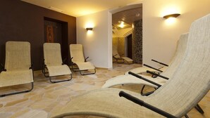 A room with four lounge chairs arranged in a semi-circle, a stone floor, and a staircase leading to another area. - Aparthotel Kronplatz Luxury House (Valdaora)