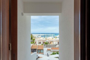 A view from a balcony overlooking a marina with boats and buildings. - Albergo Auralba (San Vito Lo Capo)