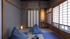 A traditional Japanese room with tatami flooring, a shoji screen, and a tea set on a tray.