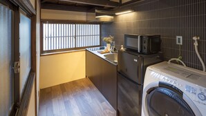 A compact kitchen with a washing machine, microwave, and a small sink.