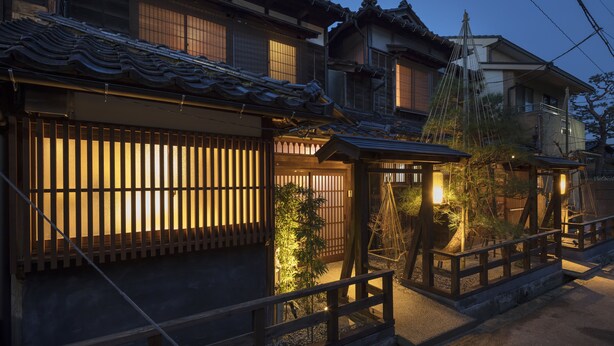 A traditional Japanese building with wooden sliding doors and a tiled roof.