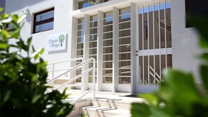A building entrance with a sign reading "Estação do Parque" and a staircase leading up to a door with vertical bars. - Estação do Parque (Santa Maria da Feira)
