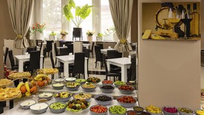 A buffet setup with various food items and a wine display. - Hotel Grand Palace Tbilisi (Tbilisi)