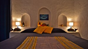 A bedroom with a bed, two nightstands, and a wall-mounted fish decoration. - Poecylia Resort (Carloforte)