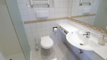 A bathroom with a toilet, sink, and towel rack.