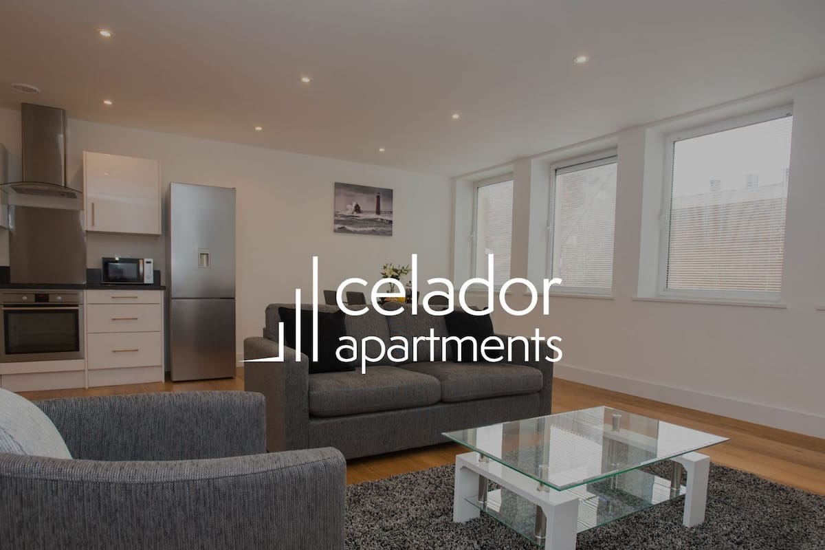 Un appartement moderne doté d’une cuisine, d’un espace de vie et de grandes fenêtres.