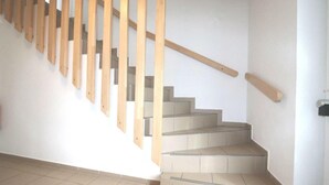A staircase with wooden handrails and beige tiles. - Penny-Pension (Gross Twulpstedt)